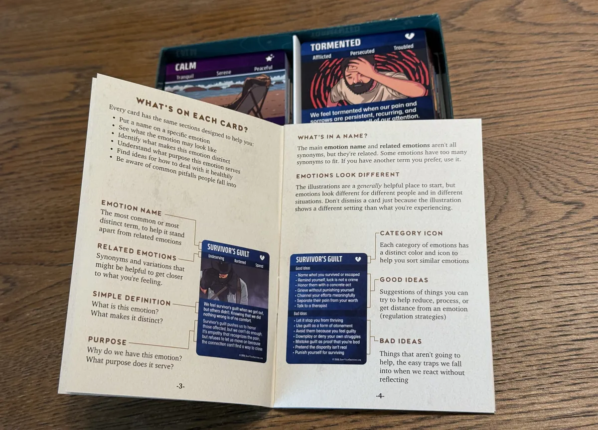 The guidebook open to the page explaining what is on each card, resting on the open box of cards